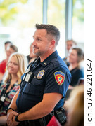 Police officer listening attentively during community meeting. Стоковое AI-изображение, AI-художник Юрий Поздников / Фотобанк Лори