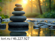 A tower of smooth stones neatly stacked on top of each other in a pond. The stones are reflected in the calm water, creating a harmonious symmetry. In the background, a blurry forest is visible, illuminated by the soft warm light of the setting or rising sun. The atmosphere is filled with calm, balance and peace. This image conveys the idea of ​​harmony with nature, zen and meditation. Стоковое AI-изображение, AI-художник Анна Кривицкая / Фотобанк Лори