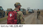Man in a red backpack with a cross on it is standing on a road. Стоковое AI-видео, аниматор Sergey Grishin / Фотобанк Лори
