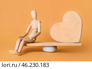 Mannequin and wooden heart on teeterboard against color background. Concept of balance. Стоковое фото, фотограф Pixel_shot / Фотобанк Лори