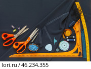 Top view of sewing accessories and materials for sew and cutting on blue silk fabric - threads, needles, scissors, pattern, pincushion. Sewing as a hobby. Flat lay, closeup, copy space. Стоковое фото, фотограф Виктория Катьянова / Фотобанк Лори