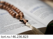 The rosary in the open Bible inspire prayer and reflection on the Word of God. Стоковое фото, фотограф Скрипачев Антон / Фотобанк Лори