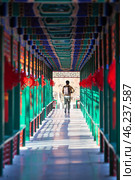 Man passing through the beautiful corridor with Chinese traditional ancient pavilions. Imperial City in the center of Beijing, China (2024 год). Стоковое фото, фотограф Кекяляйнен Андрей / Фотобанк Лори