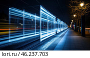 Night cityscape with the effect of a light trail from a moving tram. A long exposure created the illusion of a futuristic light contour, which seems to draw a transparent tram consisting of bright blue lines. On both sides of the tram rails, lanterns are visible illuminating the sidewalk, and city lights can be guessed in the distance. In the background, there are trees without leaves, creating a contrast between nature and the man-made world. Стоковое AI-изображение, AI-художник Анна Кривицкая / Фотобанк Лори