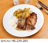 Lunch is served on plate - pieces of young rabbit cooked with segments of potato. Close-up. Стоковое фото, фотограф Яков Филимонов / Фотобанк Лори