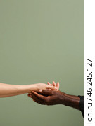 Caucasian woman and African-American man holding hands together on color background. Racism concept. Стоковое фото, фотограф Pixel_shot / Фотобанк Лори