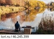 Serenity of Autumn Fishing by the Tranquil Riverside at Golden Hour. Стоковое фото, фотограф Aleksandr Golubev / Фотобанк Лори
