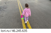 Girl child toddler walking outside in puddles on cloudy day. Стоковое видео, видеограф Spirit River / Фотобанк Лори