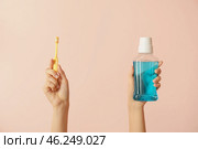 Female hands with tooth brushes and mouth rinse on color background. Стоковое фото, фотограф Pixel_shot / Фотобанк Лори