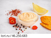 Glass bowl of tasty chipotle sauce and spices on light background. Стоковое фото, фотограф Pixel_shot / Фотобанк Лори