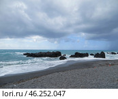 Scalea, Italy. November 10, 2024. Calabria.Dull.The sea is stormy. Waves are crashing through the rocks on an empty beach. Стоковое фото, фотограф Мария Фетисова / Фотобанк Лори