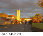 Scalea, Italy. November 19, 2024. Calabria.Sunset, view of the city church and bell tower with clock. Редакционное фото, фотограф Мария Фетисова / Фотобанк Лори