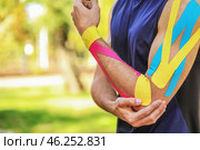 Sporty man with physio tape applied on arm outdoors, closeup. Стоковое фото, фотограф Pixel_shot / Фотобанк Лори