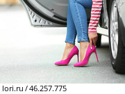 Young woman with pain in legs because of uncomfortable shoes sitting in car. Стоковое фото, фотограф Pixel_shot / Фотобанк Лори