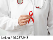 Young female doctor with red ribbon, closeup. World AIDS day concept. Стоковое фото, фотограф Pixel_shot / Фотобанк Лори