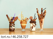 Delicious freak shakes on table against grey background. Стоковое фото, фотограф Pixel_shot / Фотобанк Лори