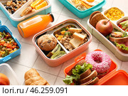 Many lunchboxes with different delicious food and bottle of juice on white tile background. Стоковое фото, фотограф Pixel_shot / Фотобанк Лори