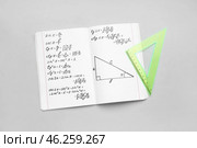Copybook with maths formulas and ruler on grey background. Стоковое фото, фотограф Pixel_shot / Фотобанк Лори