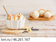 Ramekin with tasty vanilla ice cream on light wooden background, closeup. Стоковое фото, фотограф Pixel_shot / Фотобанк Лори