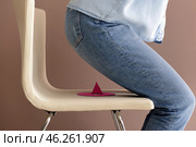 Woman is going to sit on paper pin against color background. April Fool's Day prank. Стоковое фото, фотограф Pixel_shot / Фотобанк Лори