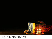 Arabic candle holder with glowing candle, Quran and tasbih on dark background. Стоковое фото, фотограф Pixel_shot / Фотобанк Лори
