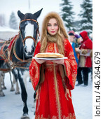 A beautiful girl in national dress treats with pancakes on Maslenitsa. Maslenitsa week. Стоковое AI-изображение, AI-художник Сергей Елизарьев / Фотобанк Лори