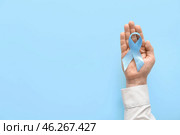 Male hand with blue ribbon on color background. Prostate cancer awareness concept. Стоковое фото, фотограф Pixel_shot / Фотобанк Лори