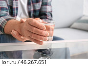 Senior man with Parkinson syndrome taking glass of water from table, closeup. Стоковое фото, фотограф Pixel_shot / Фотобанк Лори