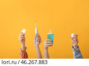 Female hands with toothbrush, mouth rinse and dental floss on color background. Стоковое фото, фотограф Pixel_shot / Фотобанк Лори