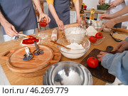 Group of young people with Italian chef preparing pizza during cooking class in kitchen, closeup. Стоковое фото, фотограф Pixel_shot / Фотобанк Лори