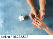 Young man putting engagement ring on fiancee's finger. Стоковое фото, фотограф Pixel_shot / Фотобанк Лори