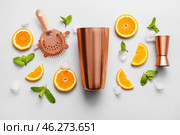 Copper strainer, cobbler shaker, double jigger and cocktail ingredients on grey background. Стоковое фото, фотограф Pixel_shot / Фотобанк Лори