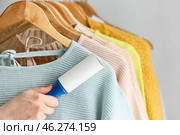 Woman cleaning clothes with lint roller, closeup. Стоковое фото, фотограф Pixel_shot / Фотобанк Лори