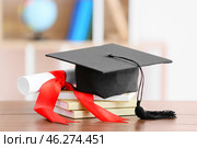 Graduation hat with diploma and books on table indoors. Стоковое фото, фотограф Pixel_shot / Фотобанк Лори