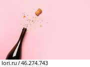 Bottle of champagne and glitters on color background. New year celebration. Стоковое фото, фотограф Pixel_shot / Фотобанк Лори