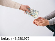 Man giving alimony to his ex-family on light background. Стоковое фото, фотограф Pixel_shot / Фотобанк Лори