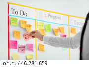 Man with sticker near scrum task board in office. Стоковое фото, фотограф Pixel_shot / Фотобанк Лори