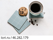 Drink coasters with cup of coffee, cookie and beans on white table. Стоковое фото, фотограф Pixel_shot / Фотобанк Лори