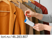 Woman cleaning clothes with lint roller, closeup. Стоковое фото, фотограф Pixel_shot / Фотобанк Лори