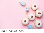 Donuts and dreidels for Hanukkah on color background. Стоковое фото, фотограф Pixel_shot / Фотобанк Лори