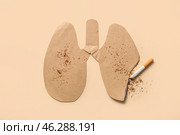 Burnt paper lungs and cigarette butts on beige background. No tobacco day. Стоковое фото, фотограф Pixel_shot / Фотобанк Лори