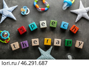 Cubes with text SPEECH THERAPY, pacifiers and toys on grey background. Стоковое фото, фотограф Pixel_shot / Фотобанк Лори
