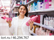 Positive salesgirl helping to choose hair products in cosmetic store. Стоковое фото, фотограф Татьяна Яцевич / Фотобанк Лори