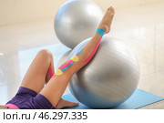 Sporty woman with physio tape training in gym. Стоковое фото, фотограф Pixel_shot / Фотобанк Лори