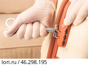 Male thief trying to open stolen suitcase, closeup. Стоковое фото, фотограф Pixel_shot / Фотобанк Лори