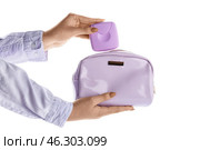 Tampons storage box and cosmetic bag in female hands on white background. Стоковое фото, фотограф Pixel_shot / Фотобанк Лори