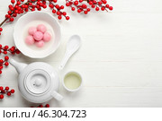Bowl of tangyuan with teapot, cup and berries on white wooden background. Dongzhi Festival. Стоковое фото, фотограф Pixel_shot / Фотобанк Лори