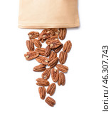 Paper bag with scattered pecan nuts on white background. Стоковое фото, фотограф Pixel_shot / Фотобанк Лори