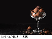 Glass bowl with sweet truffles on dark background. Стоковое фото, фотограф Pixel_shot / Фотобанк Лори