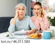 Mother and daughter figuring out finance problem. Стоковое фото, фотограф Яков Филимонов / Фотобанк Лори